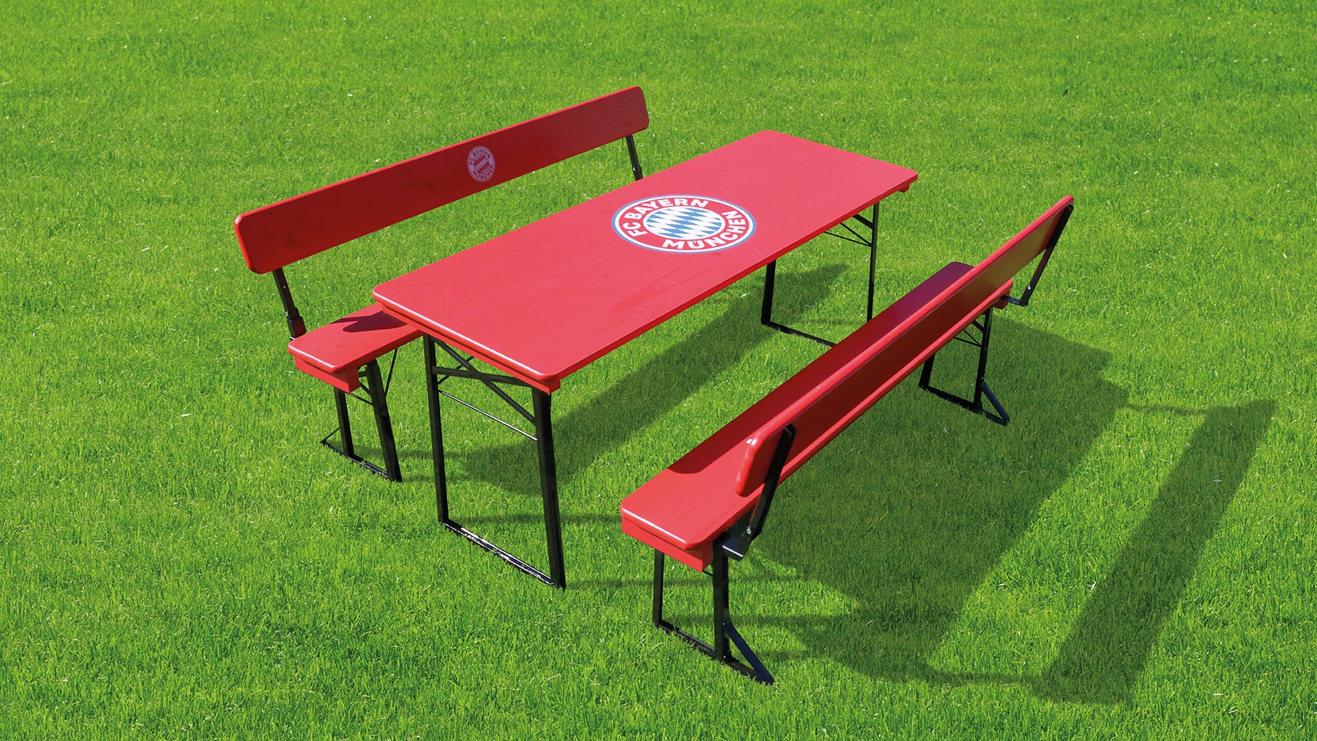 Die Bierzeltgarnitur mit Lehne im FC Bayern München Design auf dem Rasen.