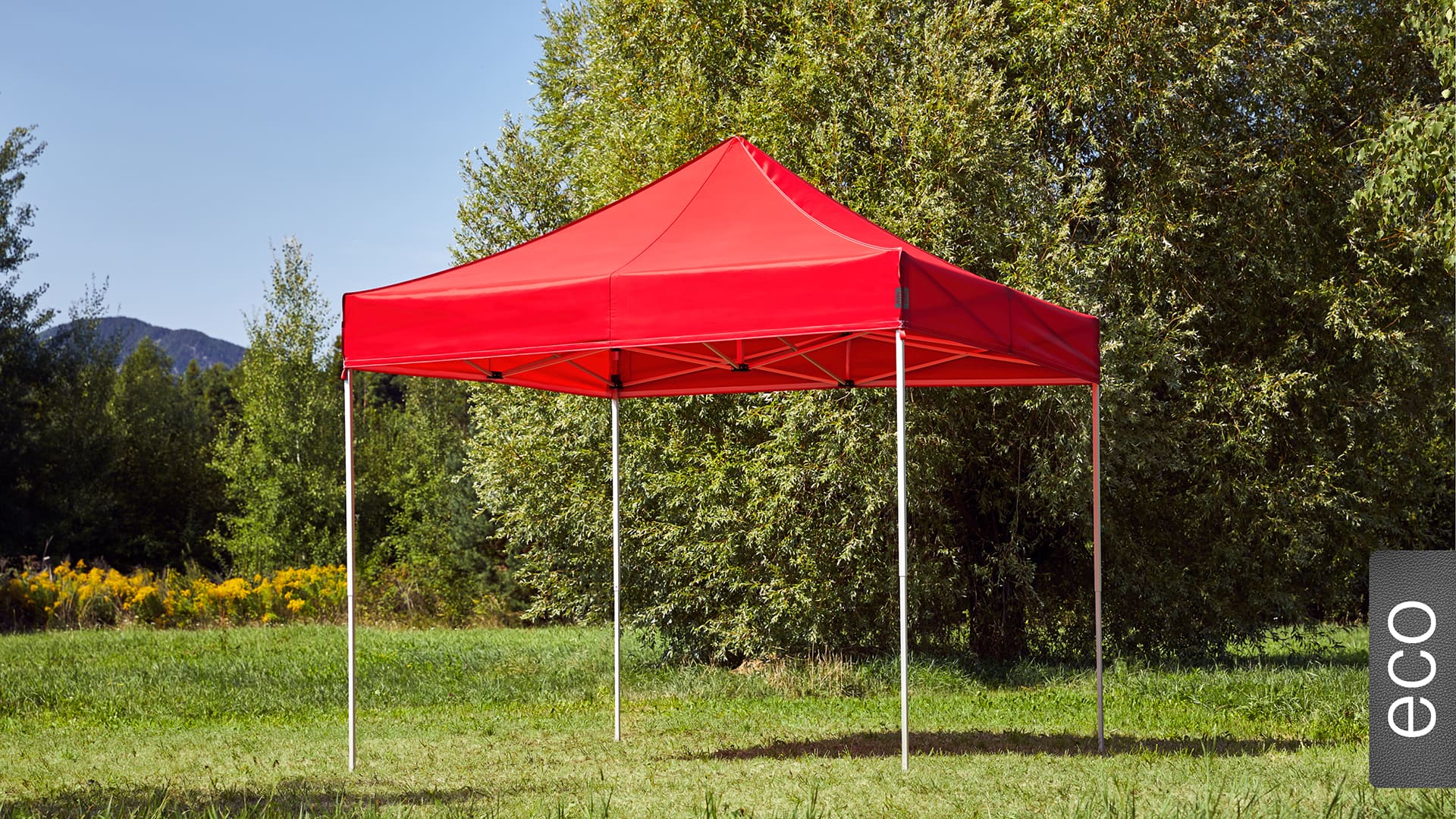 Der 3x3 Faltpavillon der Produktlinie eco mit einem roten Dach aufgestellt im Garten.